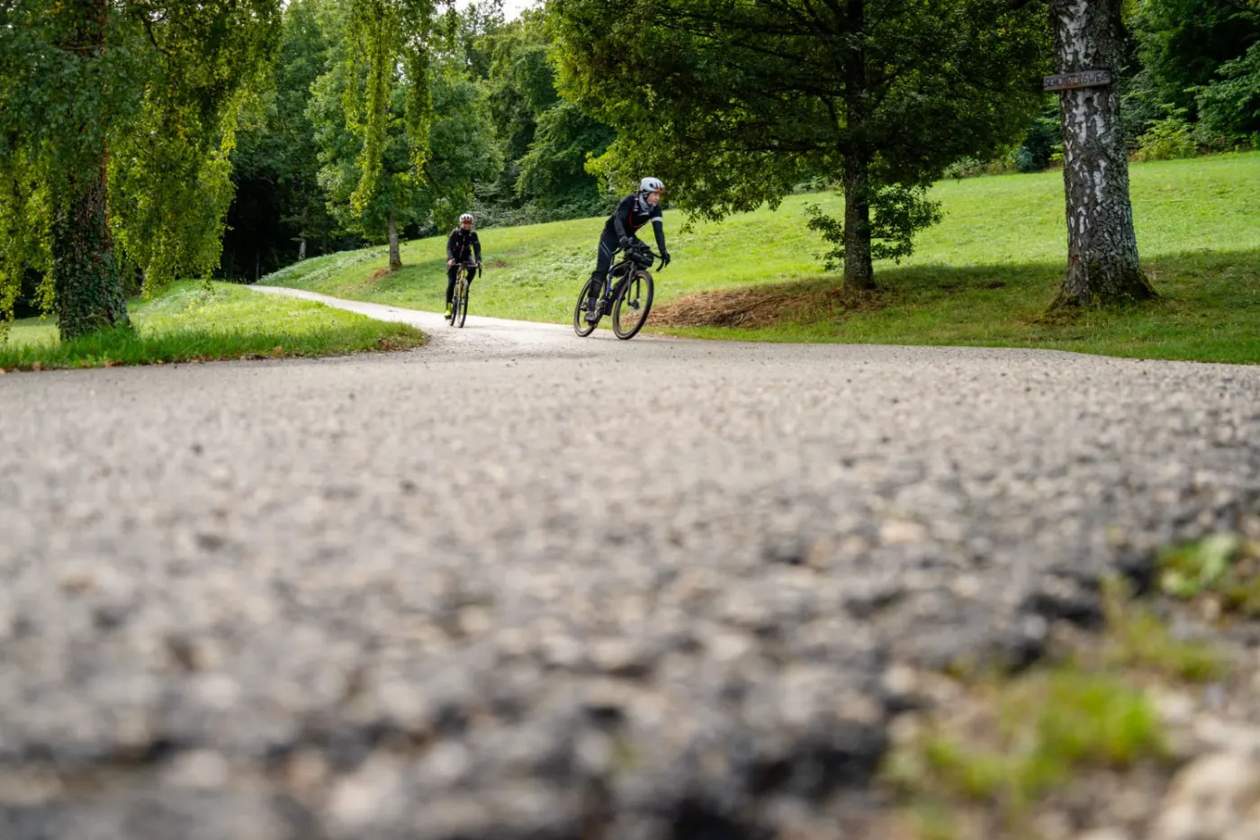 Zwei Fahrer auf geschwungenem Schotterweg